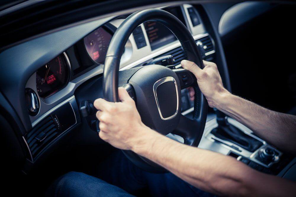 an image of person holding steering wheel